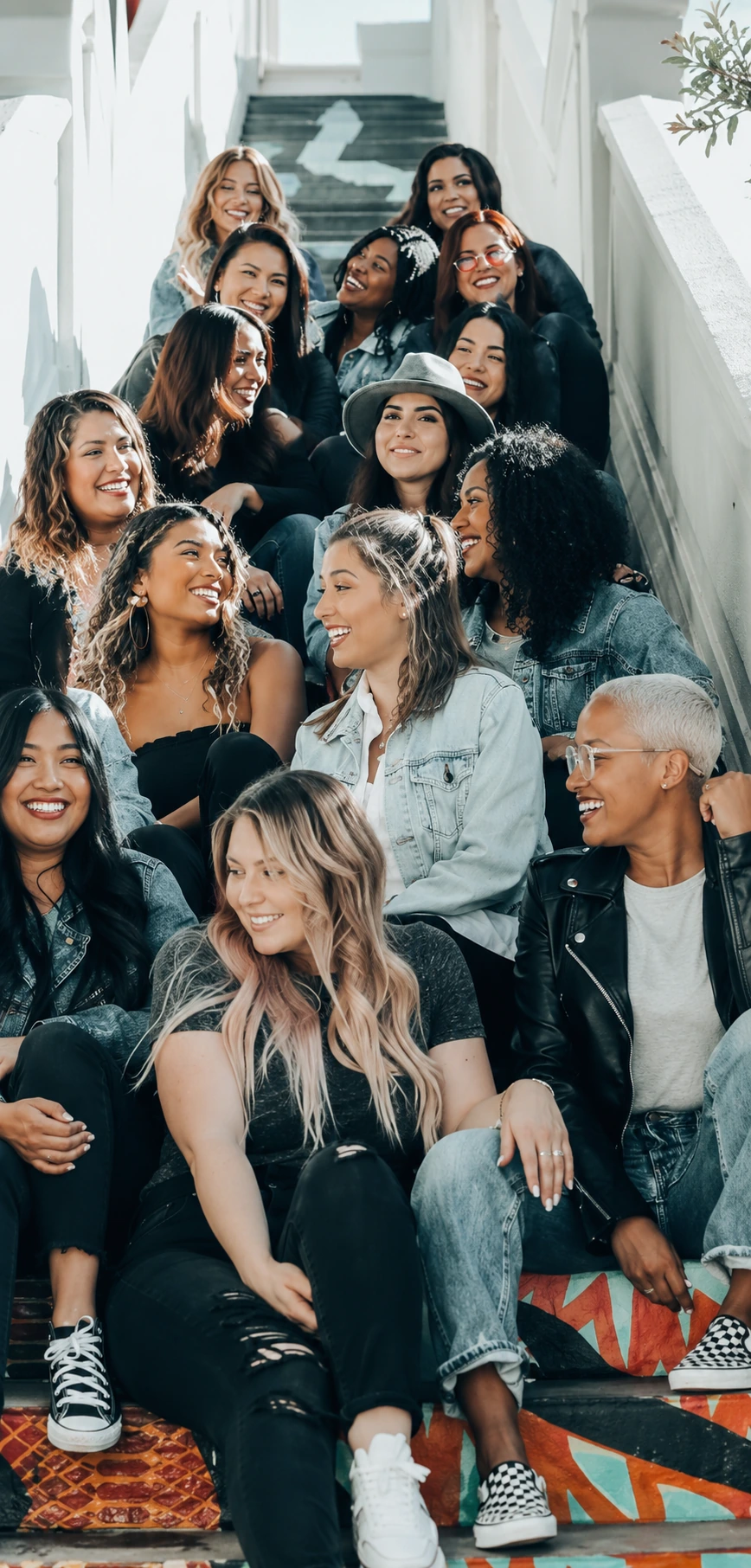 A large group of young women sitting together on outdoor steps